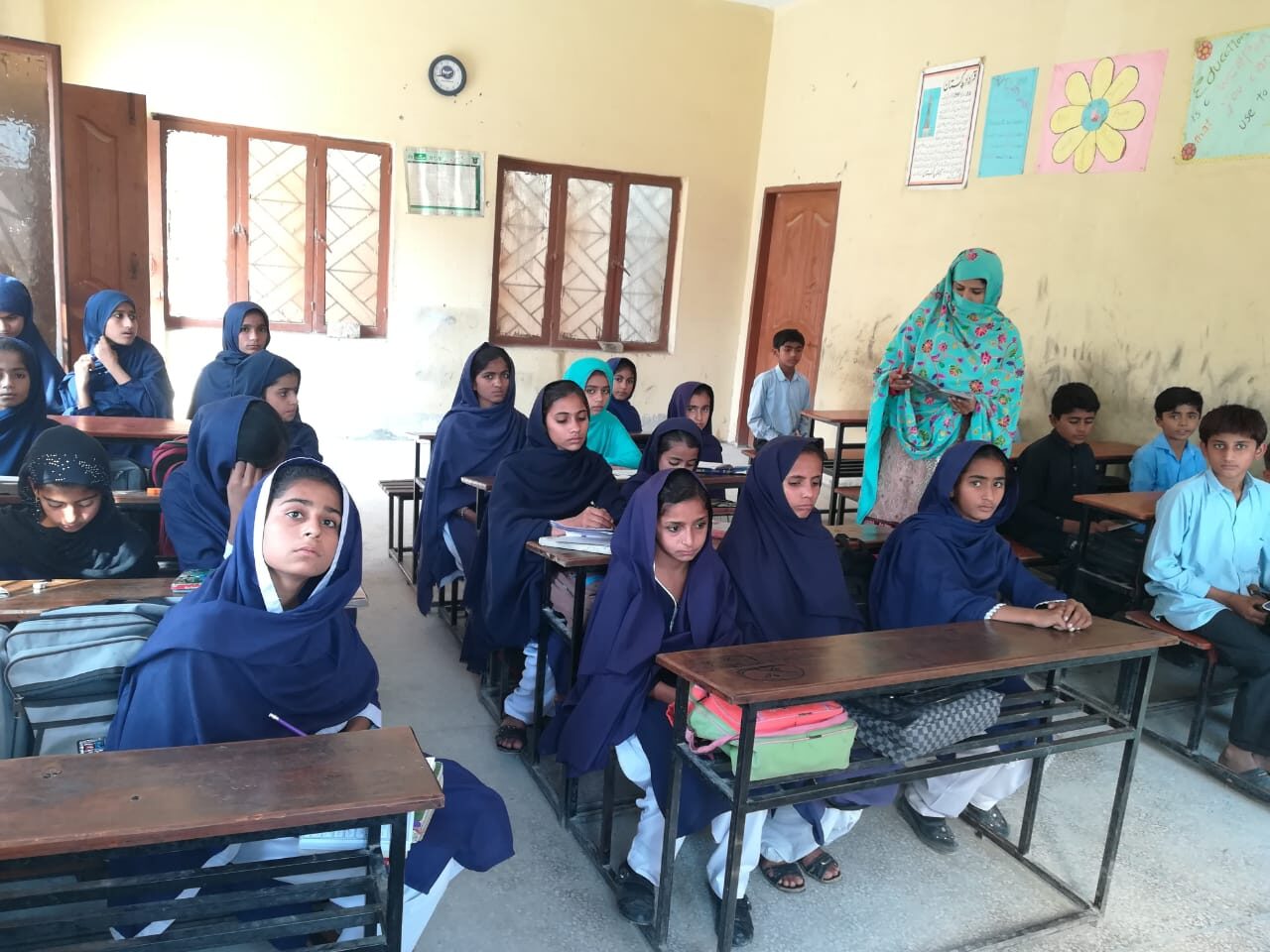 Girls and boys attending a school classroom